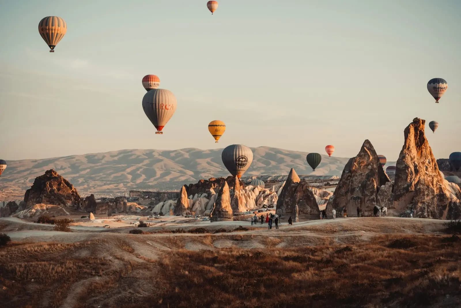 Hot air balloons rising over the rock formations of Cappadocia at sunrise